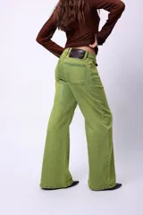 Jean de tiro alto en denim color verde vibrante, con corte flare y cierre frontal con botón metálico.