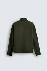 Sobrecamisa negra de corte relajado, confeccionada en tejido con mezcla de algodón elástico. Presenta cuello solapa, cierre frontal de cremallera, bolsillos de plastrón en el pecho y bolsillos de vivo en la cadera.