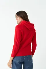 Sweater tejido color salmón con capucha y cordones ajustables.