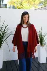 Saco abierto tipo capa en color bordó, confeccionado en tejido de punto suave, con mangas amplias y detalle de flecos en el ruedo.