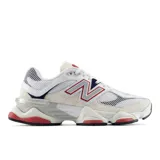 Championes New Balance modelo 9060, con diseño inspirado en la estética futurista Y2K. Presenta una combinación de malla y gamuza en tonos blanco y beige, con detalles en azul marino, rojo y plateado. Incluye el logo 'N' característico en los laterales y una entresuela esculpida de gran volumen con tecnología de amortiguación ABZORB y SBS.
