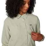 Camisa de senderismo manga larga color verde claro, con cuello clásico, cierre frontal con botones, dos bolsillos frontales con solapa y ventilaciones traseras de malla. Confeccionada en tejido técnico con tecnología de protección solar y absorción de humedad.