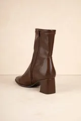 Botas negras de caña media en símil cuero, con cierre lateral y punta redondeada. Taco cuadrado de 6,5cm de alto.