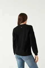 Sweater lila de punto suave con cuello redondo y hombros caídos.