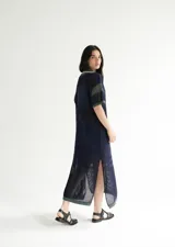 Remerón tejido de punto color azul marino con calados, cuello estilo camisa en verde oscuro con rayas blancas y verdes, y logo bordado en blanco en el pecho.