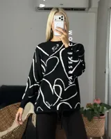 Sweater de tejido de punto con diseño abstracto de líneas blancas sobre fondo de color sólido. Presenta un corte clásico y textura suave.