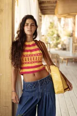 Top tejido a mano con diseño de rayas horizontales en colores fucsia y amarillo, con cuello halter y corte cropped.