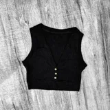 Crop top negro de lanilla con escote en V y tres botones frontales.