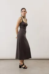 Vestido largo color verde suave, sin mangas, con escote redondo y silueta al cuerpo que se ensancha levemente hacia el dobladillo.
