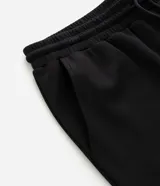 Pantalón jogger de pijama color negro, confeccionado en tejido de modal con mezcla de poliéster y elastano. Presenta cintura elástica con cordón de ajuste, bolsillos laterales y puños ajustados en el ruedo.