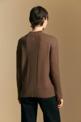 Polera de cuello alto confeccionada en tejido de punto negro, con diseño de textura acanalada en cuello, puños y ruedo, y trama vertical en mangas y espalda.