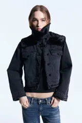 Campera de denim negro con forro de piel ecológica en el cuerpo y mangas con matelassé. Presenta doble cuello, uno de ellos desmontable, cierre frontal con botones metálicos y bolsillos tipo plaqué.