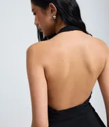Blusa frente única de Blue Steel, confeccionada en bengalina color negro. Presenta un escote profundo en V, corte ajustado en la parte superior con ruedo levemente ampliado y bolsillos laterales decorativos.