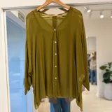 Camisa de gasa color verde oliva, de corte oversize, con escote en V, cierre frontal con botones blancos y mangas murciélago largas.