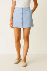 Minifalda de algodón con estampado a rayas verticales azules y blancas, con cierre frontal con botones.