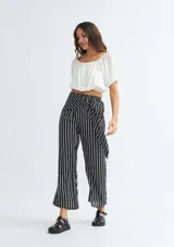 Pantalón palazzo negro con rayas verticales blancas y lazo en la cintura.
