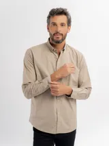 Camisa de manga larga color azul marino, confeccionada en algodón, con cuello abotonado y cierre frontal de botones.