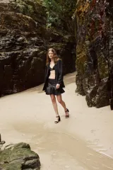 Minifalda de cuero color marrón oscuro, con fajón en la cintura y volados en el ruedo.