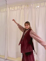 Chaleco largo de terciopelo color bordó, con corte recto y sin cierre.