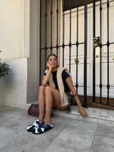 Zuecos negros con estampado de vaca en blanco y hebilla plateada.