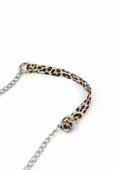 Cartera tipo bandolera con estampado animal print de leopardo, solapa frontal y correa larga de cadena metálica plateada. Presenta detalles de tachas pequeñas en los bordes.