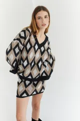 Sweater oversize con cuello en V y estampado de rombos en tonos lila, rosa y rojo. Tejido de lana artesanal.