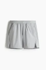 Short deportivo de tejido funcional con tecnología DryMove para absorción de sudor, con elástico en la cintura, cordón de ajuste oculto, bolsillos laterales y aberturas en el bajo.