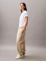 Pantalón jogger Calvin Klein de felpa color beige, con cintura elástica, bolsillos laterales y bajos de canalé. Cuenta con el monograma CK bordado en la pierna.