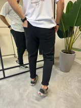 Jean de corte skinny color negro, con diseño de roturas en la rodilla y acabado desgastado. Presenta cierre frontal con botón y bolsillos laterales.