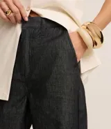 Pantalón wide leg de jeans color azul oscuro, de tiro alto, con trabillas en la cintura, bolsillos y cierre tradicional.