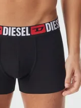 Boxer de algodón negro con cintura elástica ancha que presenta el logo de la marca Diesel en letras blancas y rojas.