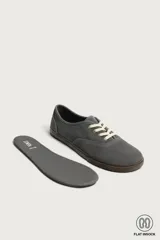Zapatilla deportiva barefoot fabricada en piel con acabado serraje de color marrón, con cordones en contraste y suela fina de goma.