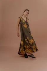 Vestido largo verde militar con estampa tropical de palmeras en tonos amarillos, escote en V y detalles en marrón.