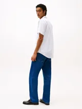 Camisa de hombre Tommy Hilfiger de manga corta, confeccionada en popelina de algodón con tecnología Flex, a rayas verticales blancas y celestes. Tiene cuello abotonado, corte regular y logo bordado en el pecho.