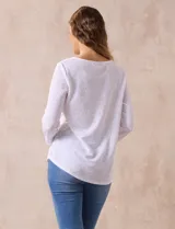 Blusa blanca de tejido labrado con cuello redondo, escote en V y aplique metálico.
