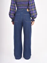 Jean de corte recto y tiro alto, color negro, con bolsillos frontales tipo parche.