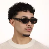 Lentes de sol con armazón de diseño ovalado y estilo envolvente, combinando tonos marrón oscuro y negro. Cuentan con protección UV400.