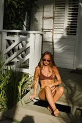 Top de bikini marrón, modelo triángulo fijo, con breteles y espalda regulables, espacio para copas de relleno y forro.