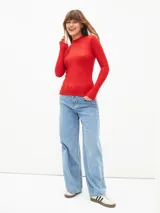 Polera de tejido acanalado en color rojo, con cuello alto y mangas largas.