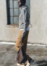 Pantalón de vestir color tostado con diseño de corte recto y tiro medio. Presenta detalle de pinzas frontales, trabillas para cinturón y cierre oculto con cremallera, botón y ganchos.
