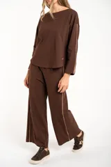 Sweater de manga larga color café, con textura gofrada y cuello redondo. Presenta una fina línea decorativa de color beige en el exterior de ambas mangas.