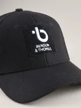 Gorra de béisbol de paño en color azul marino, con estructura de seis paneles y etiqueta pequeña con logo en el lateral.