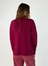 Sweater de punto color marrón chocolate, con cuello alto y puños y ruedo acanalados. Presenta un diseño holgado y mangas largas.