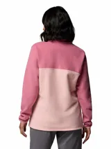 Buzo de polar con cierre frontal parcial de botones a presión, cuello alto y diseño de bloques de color en tonos rosados. Cuenta con el logo de la marca bordado en el pecho.