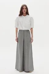 Pantalón gris de lino con diseño a cuadros, tiro medio-alto, pierna ancha y bolsillos laterales.