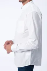 Camisa de vestir manga larga color blanco, con cuello clásico abotonado y bolsillo frontal en el pecho. Diseño de corte recto y puños ajustables con botones.