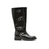 Bota de caña alta color negro, confeccionada en cuero sintético con acabado brillante. Presenta tres hebillas metálicas laterales, detalle de tachas plateadas a lo largo de la caña y una correa decorativa con argolla metálica en el tobillo. Cuenta con suela plana y taco bajo.