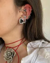 Ear cuff plateado con detalle de rosas.