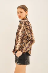 Camisa de manga larga con cuello camisero y corte masculino, confeccionada en poliéster con estampado de piel de serpiente en tonos marrones y beige.