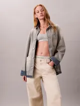 Pantalón chino de Calvin Klein, color beige, con diseño de pierna súper ancha, tiro alto, cinco bolsillos y cierre frontal con botón y cremallera.
